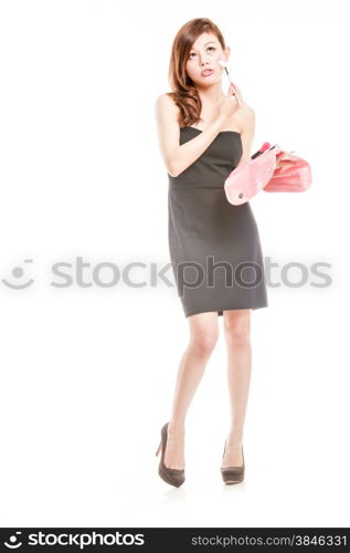 Chinese woman in black dress putting on makeup, holding pink make-up bag