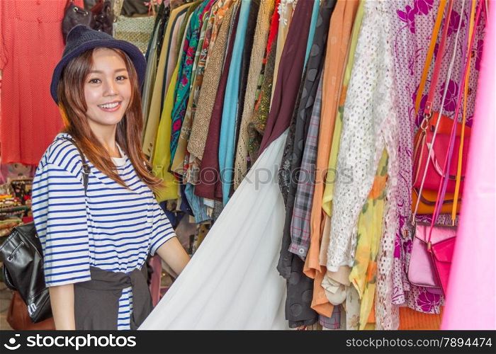 Chinese woman looking through clothes on racks at a street market in Taipei