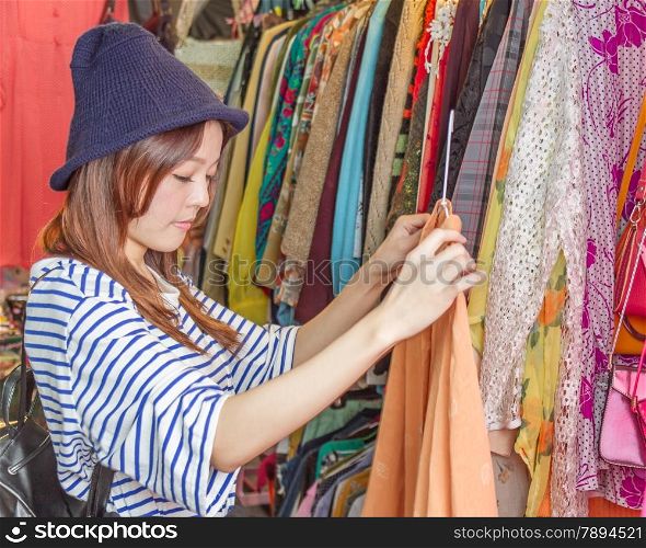 Chinese woman looking through clothes on racks at a street market in Taipei