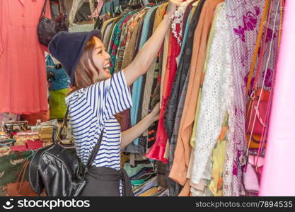 Chinese woman looking through clothes on racks at a street market in Taipei