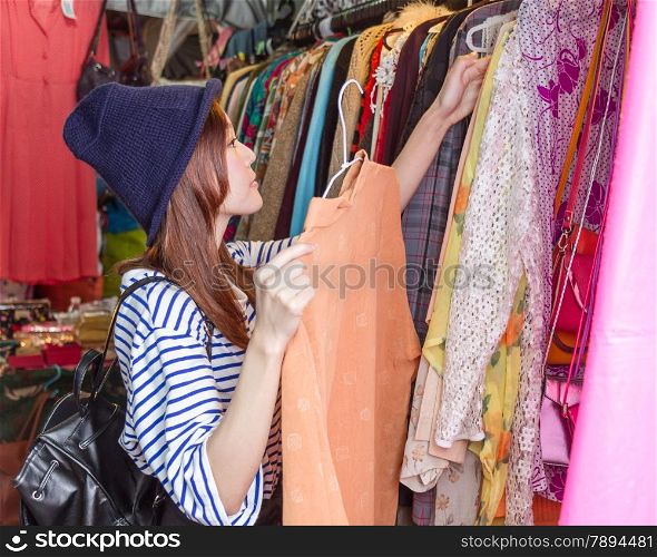Chinese woman looking through handbags on racks at a street market in Taipei