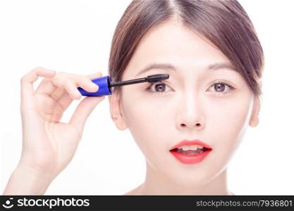 Chinese woman putting mascara on eyelashes