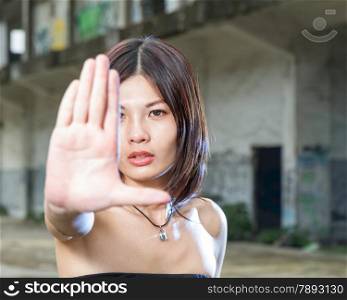 Chinese woman showing no hand gesture with old bulding in background
