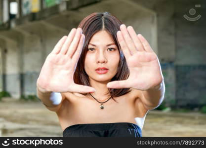 Chinese woman stretching hands out with old bulding in background