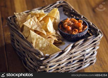 Chips nachos with salsa sauce on a wooden table&#xA;