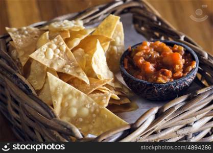Chips nachos with salsa sauce on a wooden table&#xA;
