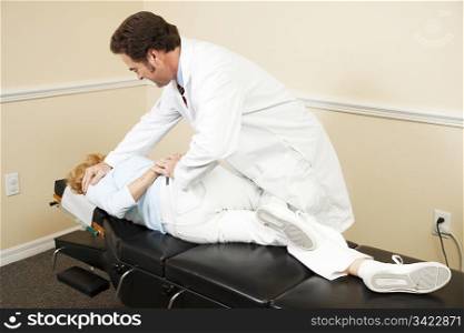 Chiropractor adjusting a patient in his office.
