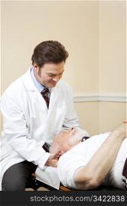 Chiropractor adjusts the neck of a senior male patient.