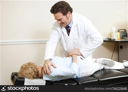 Chiropractor gently adjusting a senior woman&rsquo;s spine.