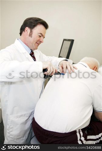Chiropractor uses a computerized tool to adjust a patient&rsquo;s back.
