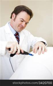 Chiropractor using an electric tool to adjust a patient&rsquo;s spine.