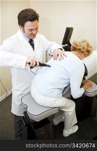 Chiropractor using an eletrical tool and computer to diagnose and adjust a patient&rsquo;s spine alignment.
