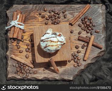 Chocobon (Soft chocolate bun) topped with rich cream cheese frosting and Cinnamon with Coffee beans on wooden with dark background. Top view, Selective focus.