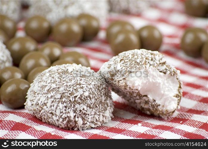 Chocolate and coconut covered marshmallow over red and white cloth