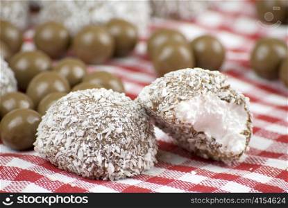 Chocolate and coconut covered marshmallow over red and white cloth
