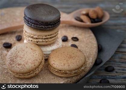Chocolate and coffee macaroons on wooden background in low light, AF point selection, copy space for write.