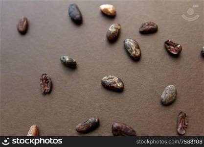 chocolate and food concept - cocoa beans on brown background. cocoa beans on brown background