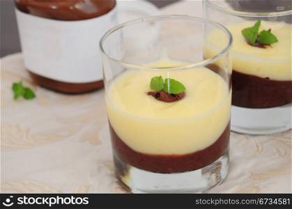 Chocolate and vanilla cream, served in glasses, decorated with mint leaf
