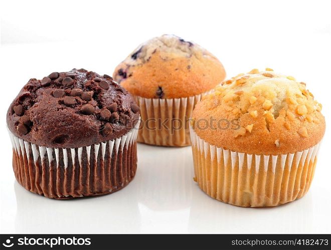 chocolate , banana and blueberry muffins on white background