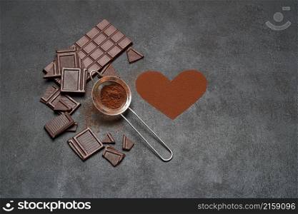 Chocolate bar and cocoa powder on dark concrete background.. Chocolate bar and cocoa powder on dark concrete background