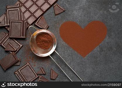 Chocolate bar and cocoa powder on dark concrete background.. Chocolate bar and cocoa powder on dark concrete background