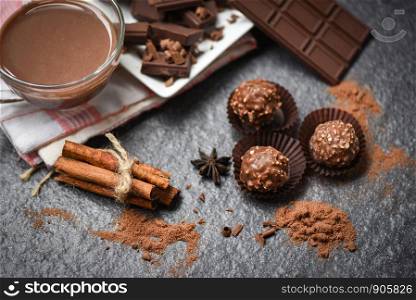 Chocolate bar and spice on the dark background / chocolate ball and chocolate pieces chunks chips powder candy sweet dessert for snack with hot cocoa drink in glass mug , selective focus