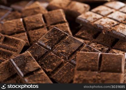 Chocolate bar, candy sweet, dessert food on wooden background. Dark homemade chocolate bars and cocoa pod on wooden