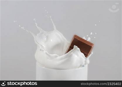 chocolate bar falling into cup of milk and splashing