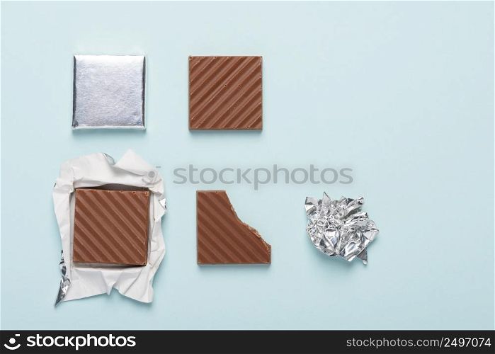 Chocolate bar life cycle on blue pastel paper background concept