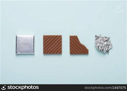 Chocolate bar life cycle on blue pastel paper background concept