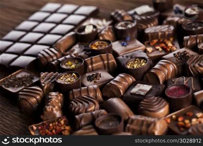 Chocolate bars and pralines on wooden background. Praline Chocolate on wooden backgroud
