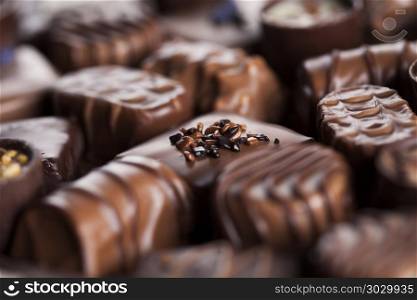 Chocolate bars and pralines on wooden background. Praline Chocolate on wooden backgroud