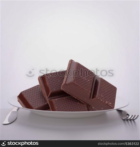 Chocolate bars stack on plate. Unhealthy eating concept.
