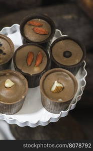 Chocolate bonbons in dish and cocoa on background