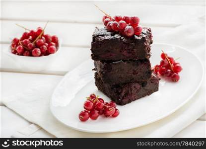 Chocolate brownie with cherries over light background, selective focus