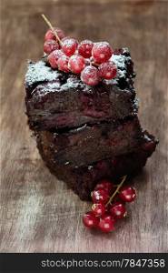 Chocolate brownie with cherries over wooden background, selective focus
