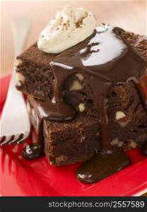 Chocolate Brownies On A Plate With Chocolate Fudge Sauce And Cream