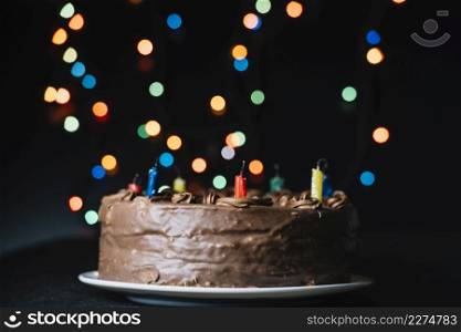 chocolate cake against glitter bokeh lights black backdrop