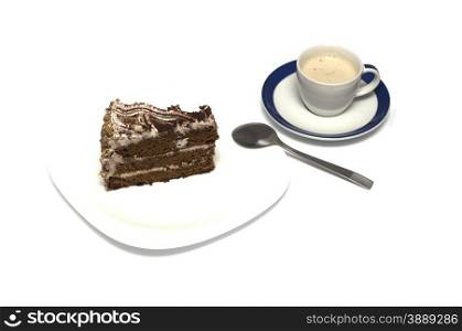 chocolate cake and mug of a cappuccino with a tea spoon