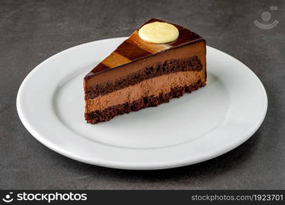 Chocolate cake on a white porcelain plate on an isolated white background