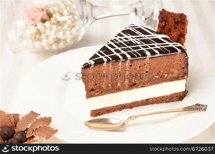 chocolate cake on the white plate with a silver spoon