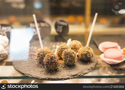 chocolate cake pops with colorful sprinkles display cabinet