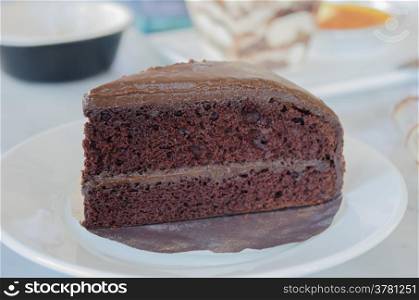chocolate cake. Slice of chocolate fudge cake on white dish