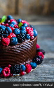 Chocolate cake with berries on wooden background