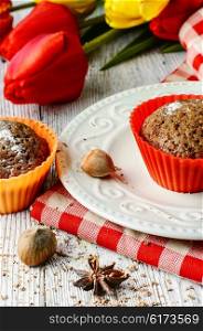 Chocolate cake with hazelnuts. muffin tins and bouquet of fresh cut tulips