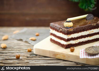 Chocolate cake with strawberry cherry and white cream on wooden table, close up, space to write.