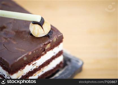 Chocolate cake with white cream on wooden table, close up, space to write, Select a focus, blurred