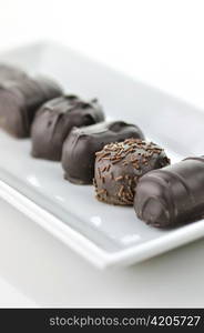 chocolate candies assortment in a white plate