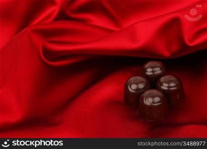 chocolate candy on red satin background