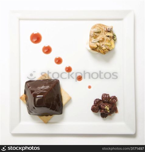 Chocolate cheesecake pyramid with dried cherries and pistachio praline.